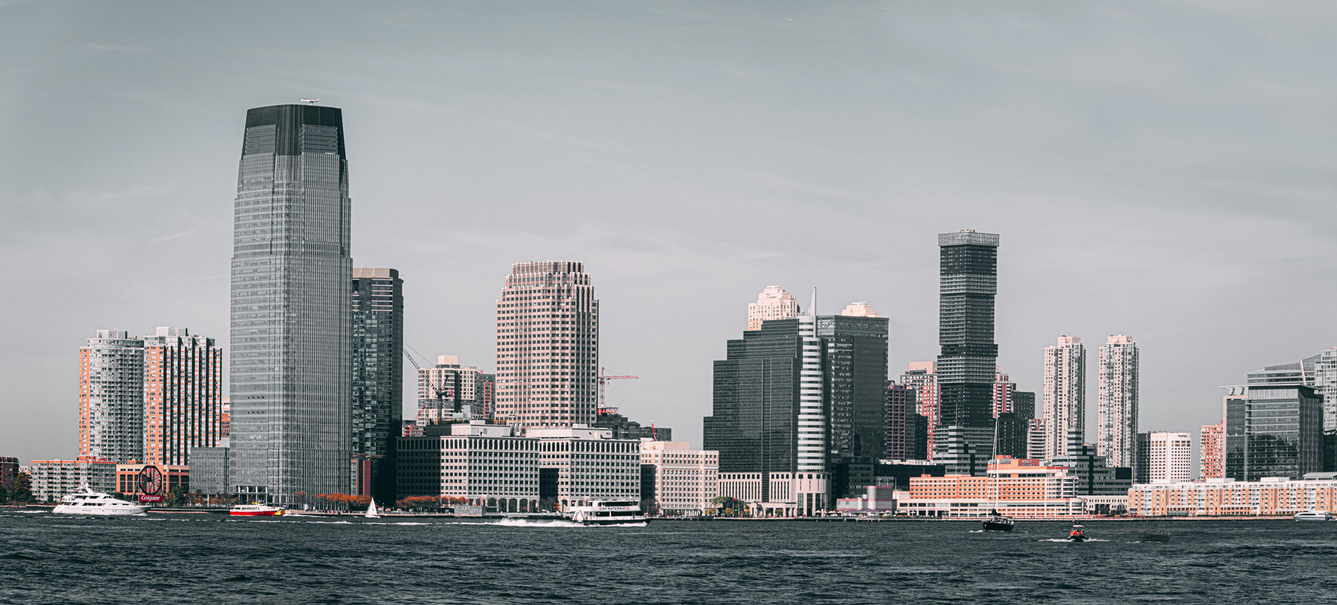 Jersey City skyline with Goldman Sachs Tower, seen across the Hudson River on overcast day.